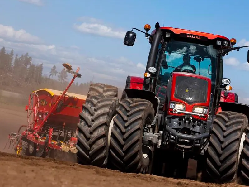 Trator com pneus agrícolas trabalhando no campo